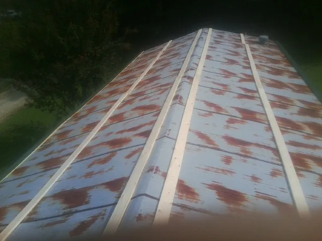 Rusted metal roof panels with new wood purlins before replacement — Storm Damage Roof Repair in Hilliard by Roofing Brothers