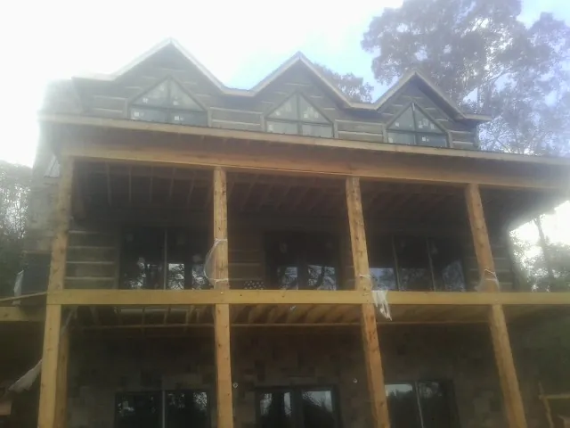Dormers and porch framing on a large log home under construction — Roof Coating work by our crew in Hilliard