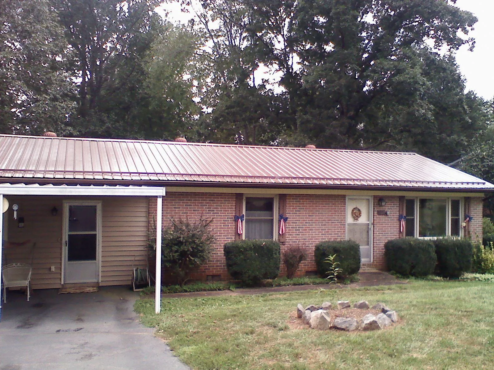 Bronze metal roof and carport on a brick ranch home — Roof Repair work by our crew in Hilliard
